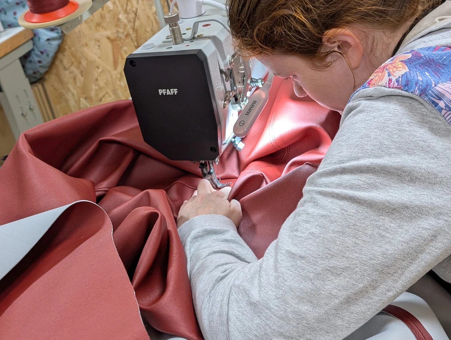 Évangéline à sa machine à coudre dans son atelier